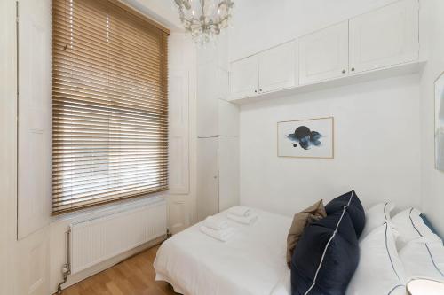 伦敦Notting Hill Apartment的一间卧室配有一张床,窗户配有吊灯