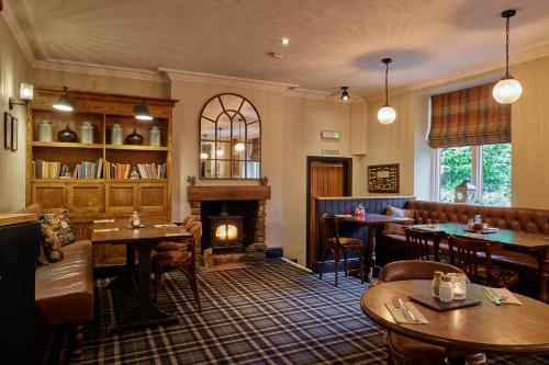 布莱克本The Ribchester Arms的一间带壁炉和桌椅的餐厅
