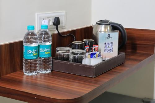 浦那StayBird - NEST, A Premium Residences, Kharadi的装有瓶装水和其他物品的架子