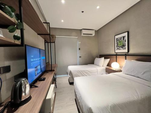 GuiguintoAcro Residences的酒店客房设有两张床和一台平面电视。