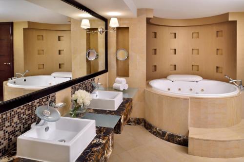 阿布扎比阿布扎比洲际酒店的浴室配有2个盥洗盆和1个浴缸。