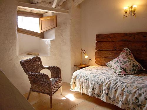 蒙塞尼Ca l'Agnès的卧室配有床、椅子和窗户。