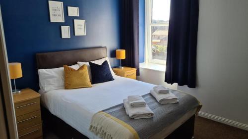 弗雷泽堡达夫隆酒店的蓝色卧室,配有带毛巾的床