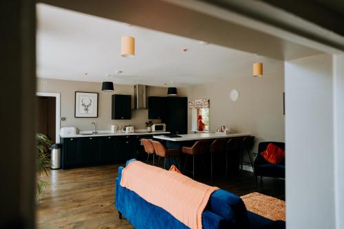 阿斯克The Stables Apartment at Cefn Tilla Court, Usk的厨房以及带桌椅的起居室。