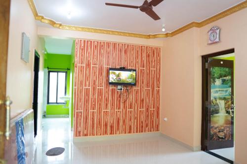 CorgaoDhanashree Riverview Hotel的一间设有木墙的客房,配有电视