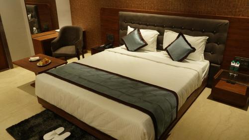 舍地Alaukik Hotel的酒店客房带一张大床和一把椅子