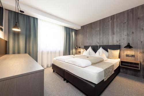 奥伯古格尔维尔沃公寓式酒店的一间卧室设有一张大床和木墙