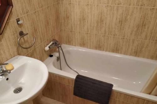 福米加尔Ático Elurra FORMIGAL的浴室配有盥洗盆和白色浴缸。