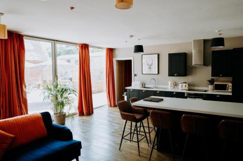 阿斯克The Stables Apartment at Cefn Tilla Court, Usk的厨房配有红色窗帘和桌椅