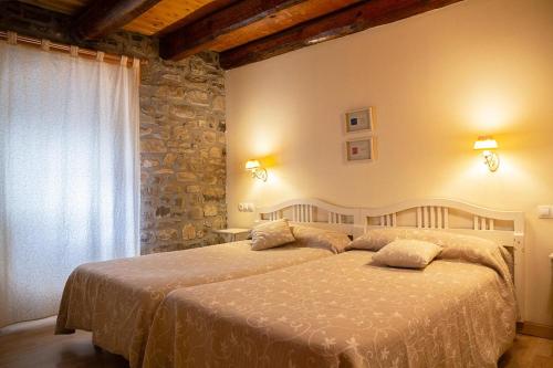 伊萨瓦Garxo Apartamentos的一间卧室设有一张床和石墙