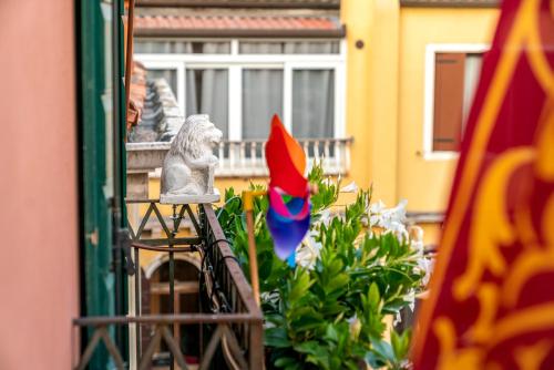 威尼斯圣卢卡宫住宿加早餐旅馆的阳台享有雕像和鲜花的景致。