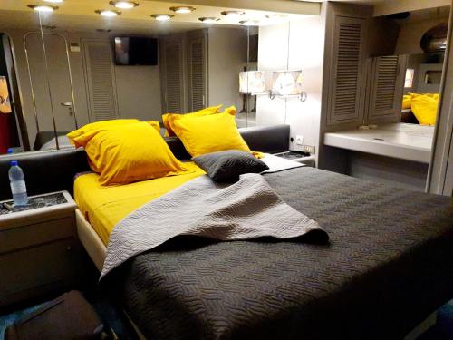 格吕桑Loc de cabines sur Yacht的一间卧室配有一张带黄色枕头和镜子的床