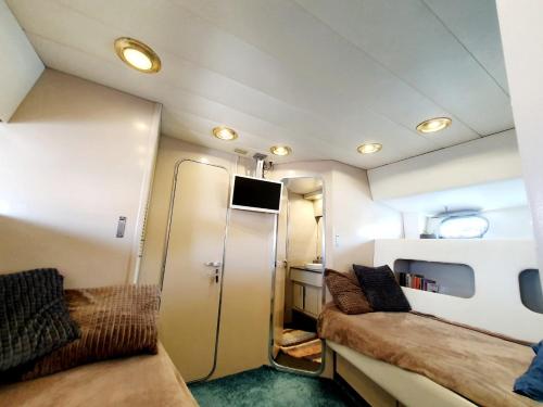 格吕桑Loc de cabines sur Yacht的小房间设有两张床和一台冰箱