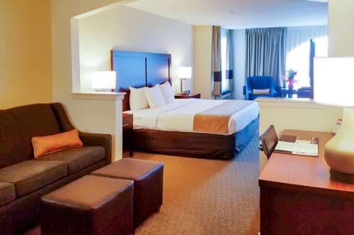 欧文Quality Suites Las Colinas Center的酒店客房,配有床和沙发