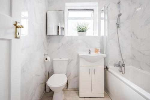 罗姆福特Lovely 4-BedRoom House Near Romford Station的白色的浴室设有卫生间和水槽。