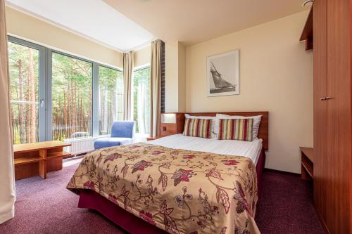 帕兰加Meduza Hotel的一间卧室设有一张床和一个大窗户