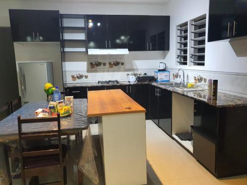 苏瓦Single Room with Shared Kitchen and Living Room的厨房配有黑色橱柜和木制台面