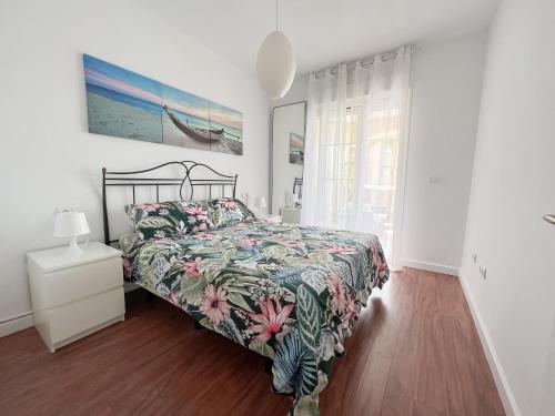 托雷德尔马尔Apartamento Narváez- Altos Del Tomillar的一间卧室配有一张带花卉床罩的床