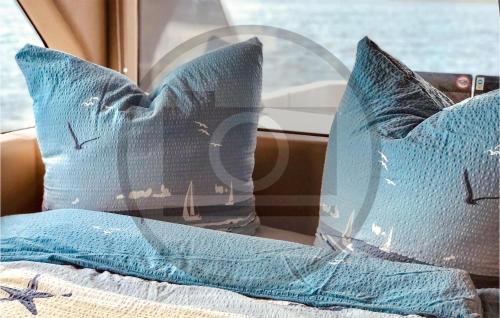 诺伊鲁平Awesome Ship In Neuruppin With Kitchen的两块蓝色枕头坐在汽车床上
