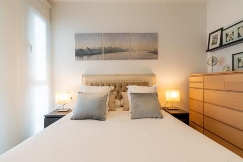 塞维利亚Veoapartment Rastro的一间卧室配有一张带两盏灯的大型白色床。