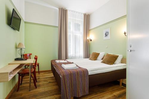 派尔努阔杜拉公园酒店的配有一张床和一张书桌的酒店客房