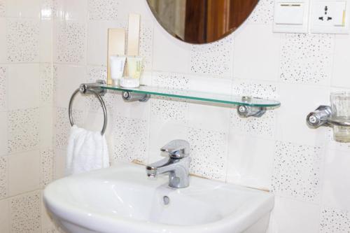 阿克拉Lou Ralph Hotel的浴室设有白色水槽和镜子