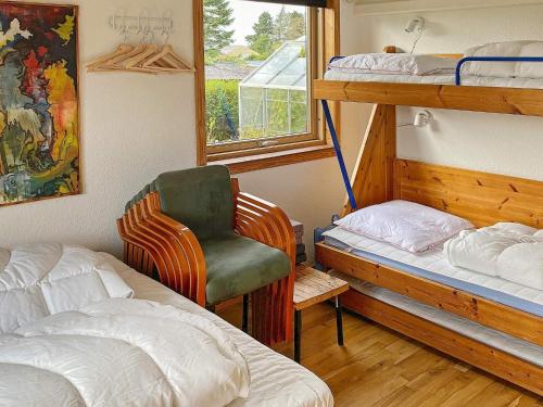 SkibbyHoliday home Skibby XIV的一间卧室配有两张双层床和椅子