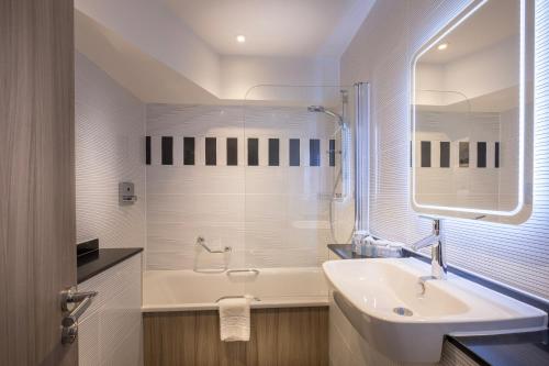 伦敦City Sleeper at Royal National Hotel的白色的浴室设有水槽和浴缸。