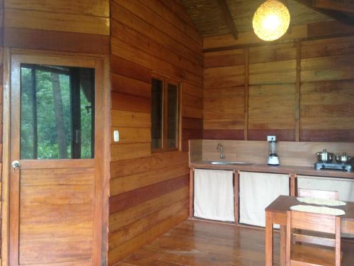 塔拉波托La Musa Verde的厨房设有木墙、门和桌子