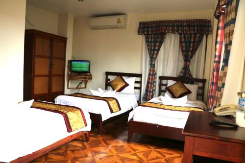 万象Mali Namphu Hotel的酒店客房设有三张床和电视。