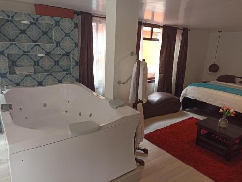 巴尼奥斯J旅馆的带浴缸的浴室和1间带1张床的卧室