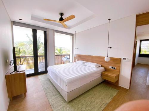 富国Phoenix Pool Villa Phu Quoc的一间卧室配有一张床和吊扇