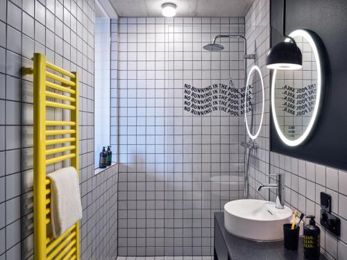 科隆STAYERY Köln Ehrenfeld的白色瓷砖浴室设有水槽和镜子