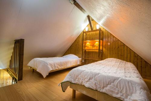 梅特泽拉Chalets de la Wormsa的阁楼卧室设有两张床,位于阁楼。