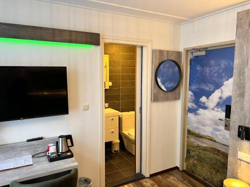 西泰尔斯海灵纳普酒店的一间带卫生间的浴室和墙上的电视