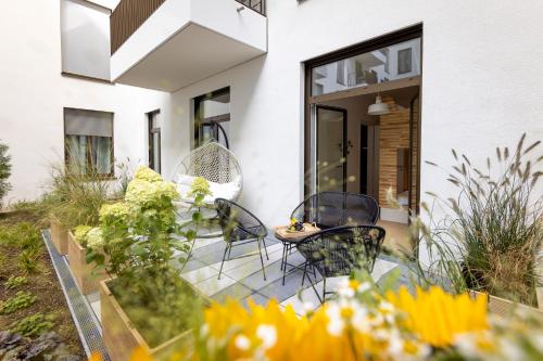 柏林Pure Berlin Apartments - Luxury at Pure Living in City Center的房屋前方带椅子和鲜花的庭院
