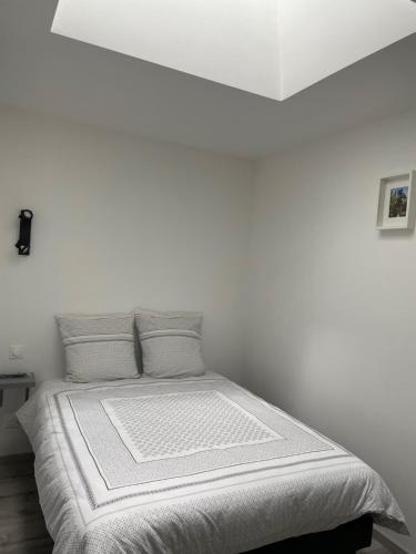 BersonGîte Le petit quartier的白色卧室配有带白色床单和枕头的床
