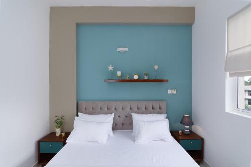 马哈拉贾马The Luxury Nest的卧室配有白色床和蓝色墙壁