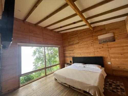 米卡Luxury Tiny House - Minca的一间卧室设有一张床和一个大窗户
