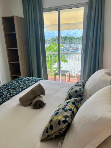 哥西尔Marina Hill Appartement vue mer的一张带枕头的床和一个美景窗户