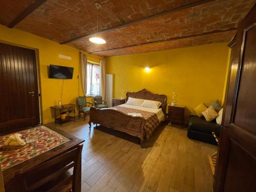 特雷伊索Le camere del Tiglio的一间卧室设有一张床和黄色的墙壁