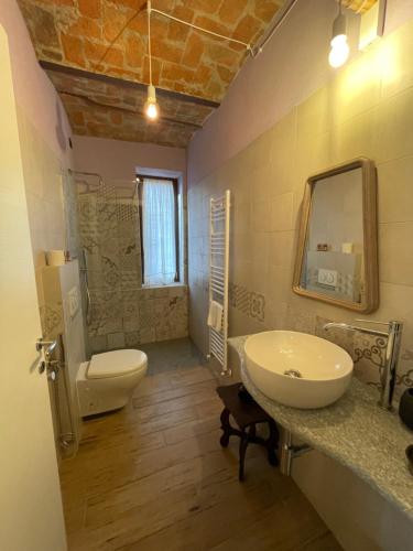 特雷伊索Le camere del Tiglio的一间带水槽、卫生间和镜子的浴室