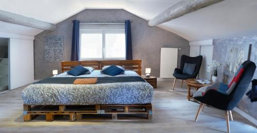默兹河畔凡尔登Chambre d'hôte et gîte chez Thomas et John的一间卧室配有一张大床和两把椅子