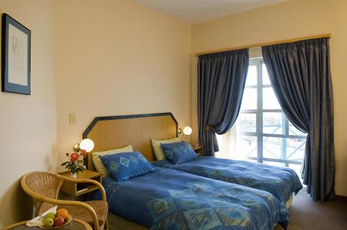 吕德里茨Sea-View Zum Sperrgebiet的一间卧室配有一张带蓝色床单的床和一扇窗户。