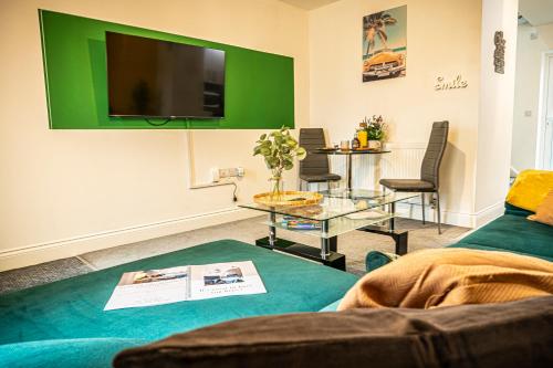 斯旺西Spacious 1-Bedroom Home with free private parking的客厅配有沙发和墙上的电视