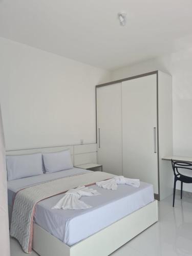 穆库热Escalada Hospedagens e Eventos的白色卧室配有一张大床和一张桌子