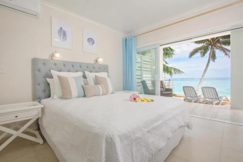 拉罗汤加Vaima Beachfront Apartments的一间卧室设有一张床,享有海景