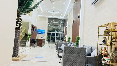 阿尔卡吉Aljadel hotel的大堂设有椅子和棕榈树