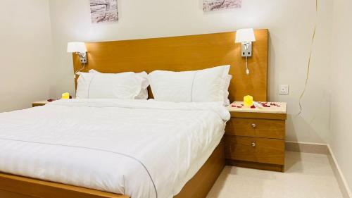 阿尔卡吉Aljadel hotel的一间卧室配有一张大床和木制床头板