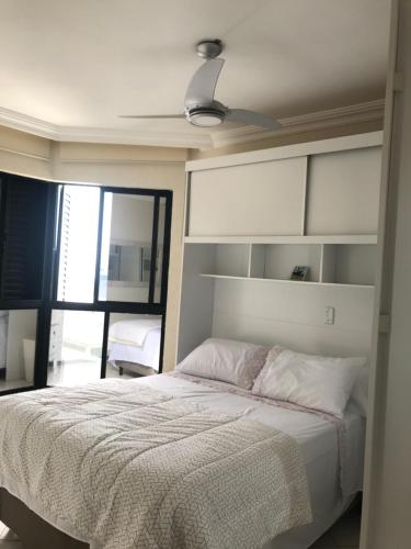 马蒂尼奥斯Lindo apartamento com vista para o mar的一间卧室配有一张床和吊扇